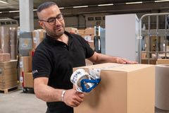Selfio Mitarbeiter im Lager verschließt ein Paket