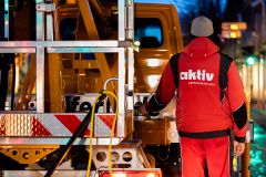  AKTIV-Mitarbeiter bei nächtlichem Einsatz an einem Fahrzeug, in Arbeitskleidung.