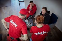 aktiv-Mitarbeitende mit Kinderwagen im Austausch. Szene im Gemeinschaftsbereich.