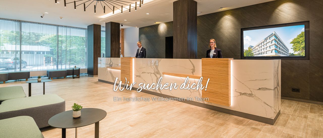 Zwei Personen an der Rezeption. Herzlich Willkommen
