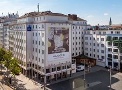 Großes Gebäude mit Werbung für Hugo’s Bar & Brasserie
