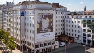 Großes Gebäude mit Werbung für Hugo’s Bar & Brasserie