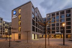 Modernes Hotel mit großen Fenstern und beleuchtetem Eingangsbereich