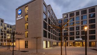 Modernes Hotel mit großen Fenstern und beleuchtetem Eingangsbereich