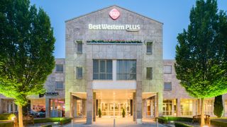 Modernes Hotel mit großen Fenstern und beleuchtetem Eingangsbereich