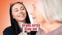 Junge Frau lächelt und kämmt der älteren Bewohnerin die Haare. So viel Gutes Dank dir.
