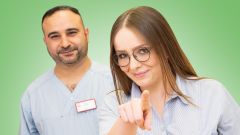 Zwei Auszubildende aus der Pflege zeigen mit dem Finger auf dich.