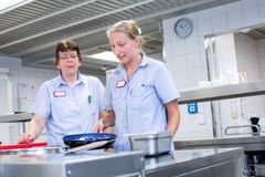 Eine Auszubildende aus der Hauswirtschaft steht mir ihrer Anleiterin am Herd und kocht. 