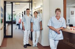 Drei Pflegekräfte stehen im Flur