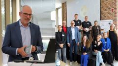 Man sieht Markus Rüdiger, den Personalleiter des Commerz Direktservices beim Bocholter Unternehmerverbund. Das linke Foto ist eine Nahaufnahme  von ihm, während seines Vortrages, rechts ist ein Gruppenbild von ihm und weiteren Teilnehmern.