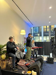 Live-Auftritt mit Gitarrist und Sängerin in gemütlicher Atmosphäre, ein Poster mit 'Yvonne Catterfeld' hängt im Hintergrund.