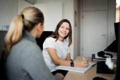 Junge Frau notiert sich wertvolle Tipps einer Ausbildungsleiterin zur Bewerbung – ein wichtiger Teil der beruflichen Orientierung.