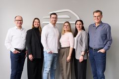 Sechs Mitarbeitende vor dem Dettmer Rail Logo