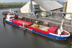 Schiff im Hafen mit Kränen und Hallen