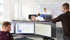 Mitarbeitende sitzen im Büro vor Bildschirmen