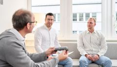 Drei Mitarbeiter sitzen in einer Besprechung