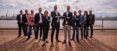Gruppenbild von Mitarbeitenden vor einem Hafen 