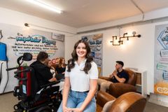 Eine Junge Frau sitzt an einem Schreibtisch und schliesst ihren Computer.