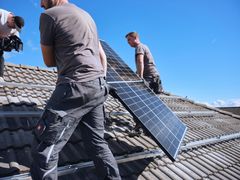 evm-Monteure installieren ein Solarpanel auf einem Dach
