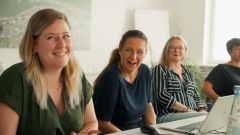 Mitarbeiterinnen der FBG in einer Besprechungssituation. Fröhliche Arbeitsatmosphäre.