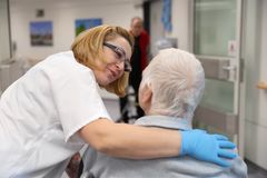 Das Bild zeigt eine Pflegefachkraft die ein Arm um einen Patienten legt