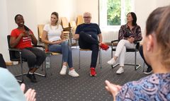 Das Bild zeigt eine Gruppentherapie mit mehreren Leuten