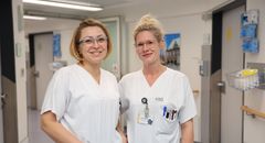 Das Bild zeigt zwei Frauen in weißer Krankenhauskleidung