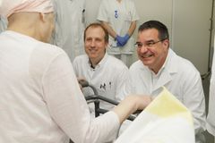 Das Bild zeigt zwei Ärzte mit einem älteren Patienten 