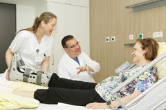 Das Bild zeigt eine Krankenschwester und ein Arzt mit einer Patientin 