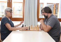 Das Bild zeigt eine Frau und ein Mann beim Schach spielen 