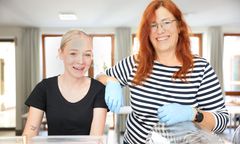 Das Bild zeigt ein junges Mädchen mit einer Mitarbeiterin