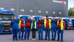 Gruppenbild mit LKW-Fahrern vor dem GRIESHABER-Logo, das die Berufskraftfahrer bewirbt