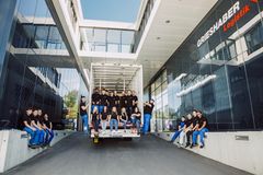 Gruppe junger Menschen in schwarzer Arbeitskleidung steht vor dem Eingangsbereich – symbolisiert Ausbildungsvielfalt und Teamzusammenhalt.