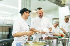 Zwei Köche bei der Zubereitung einer Suppe.