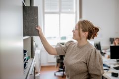 Eine Mitarbeiterin in der Verwaltung sortiert Unterlagen.