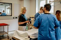 Praxisanleitende mit 2 Studierenden im Skills Lab.