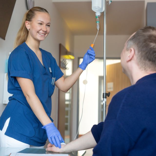Eine Frau macht eine Ausbildung zur Pflegefachkraft bei der Kaiserswerther Diakonie und unterstützt gerade einen Patienten.
