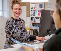 Eine Bibliotheksmitarbeiterin an der Lehrbuchausgabe.