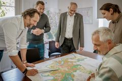 Menschen aus dem Immobilienmanagement vor einer Karte.