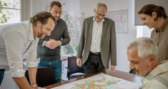 Mitarbeitende des Immobilienmanagements schauen auf eine Karte und symbolisieren die Einstiegsmöglichkeiten in diesem Bereich.