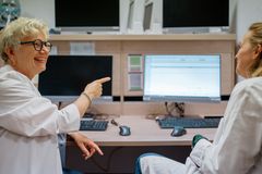 Mitarbeiterinnen sitzen gemeinsam vor einem Monitor und unterhalten sich über Ergebnisse.