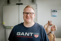 Ein Mitarbeiter lächelt in die Kamera.