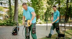 Zwei Mitarbeitende der Kaiserswerther Diakonie arbeiten mit Gartengeräten auf dem Campus.