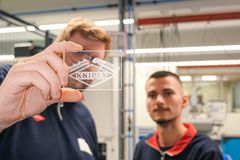 Zwei Personen schauen sich einen Glasplatte an, auf der das KNIPEX Logo eingraviert ist