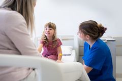 Pflegekraft unterhält sich mit einem kranken Kind