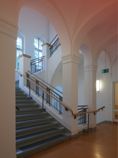 Heller Treppenaufgang mit Rundbögen in der neurologischen Fachklinik Beelitz.