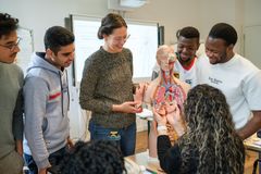 Auszubildende und Lehrerin üben am Anatomie-Modell