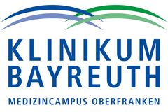 Zu sehen ist das Logo der Klinikum Bayreuth GmbH. Es ist grün und blau und enthält die Wörter "Klinikum Bayreuth" und "Medizincampus Oberfranken".