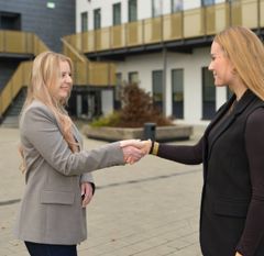 Die beiden Personen aus dem Gespräch schütteln sich die Hände - wir heißen einen neuen Mitarbeitenden willkommen.
