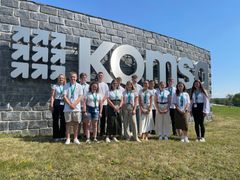 Gruppe von Auszubildenden auf dem Gelände vor dem KOMSA-Schild